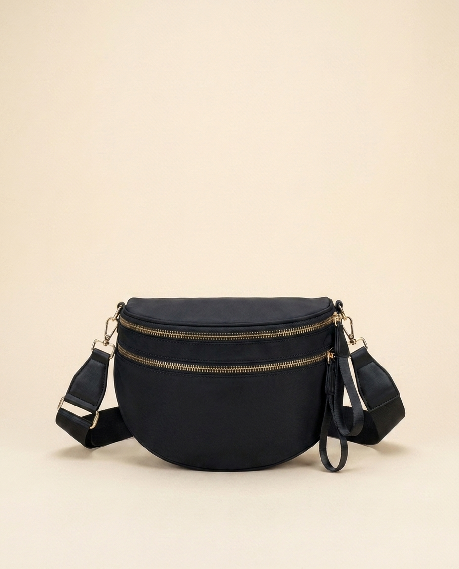 The Crescent Shoulder Bag in Ink — black nylon crossbody with gold-tone double zippers