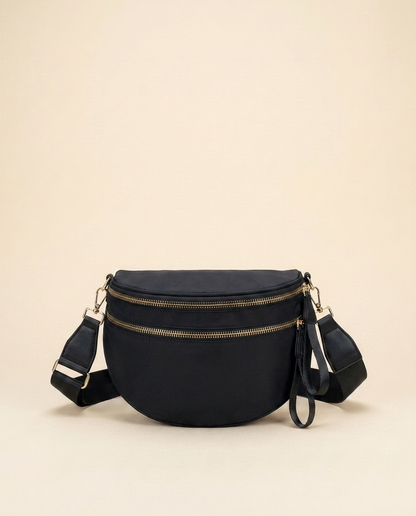 The Crescent Shoulder Bag in Ink — black nylon crossbody with gold-tone double zippers