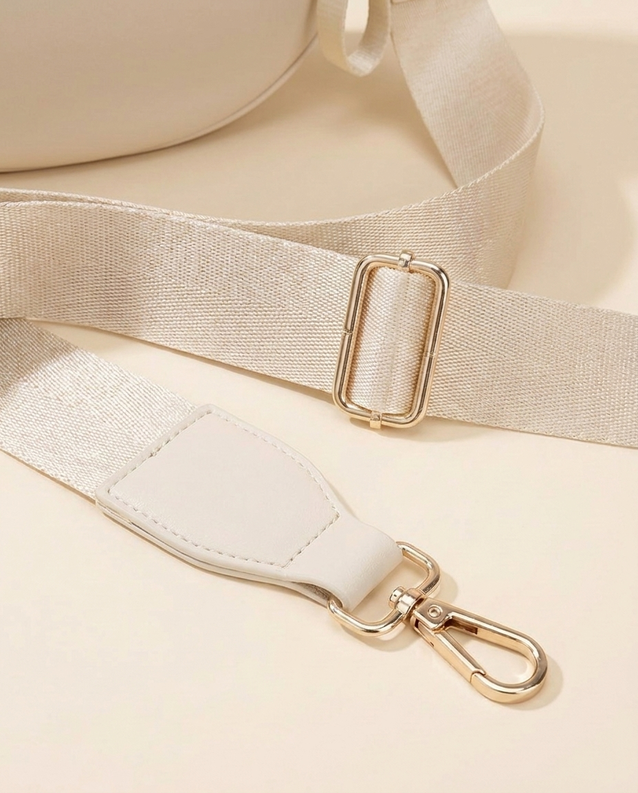 The Crescent Shoulder Bag in Sand — detail of adjustable strap with gold-tone hardware