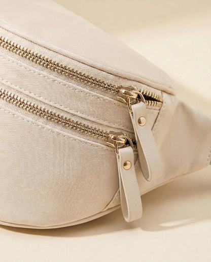 The Crescent Shoulder Bag in Sand — detail of double gold-tone zippers