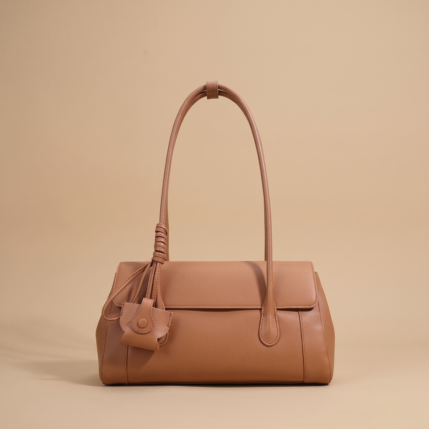 Colette Structured Leather Shoulder Bag in Cognac on a warm sand studio backdrop