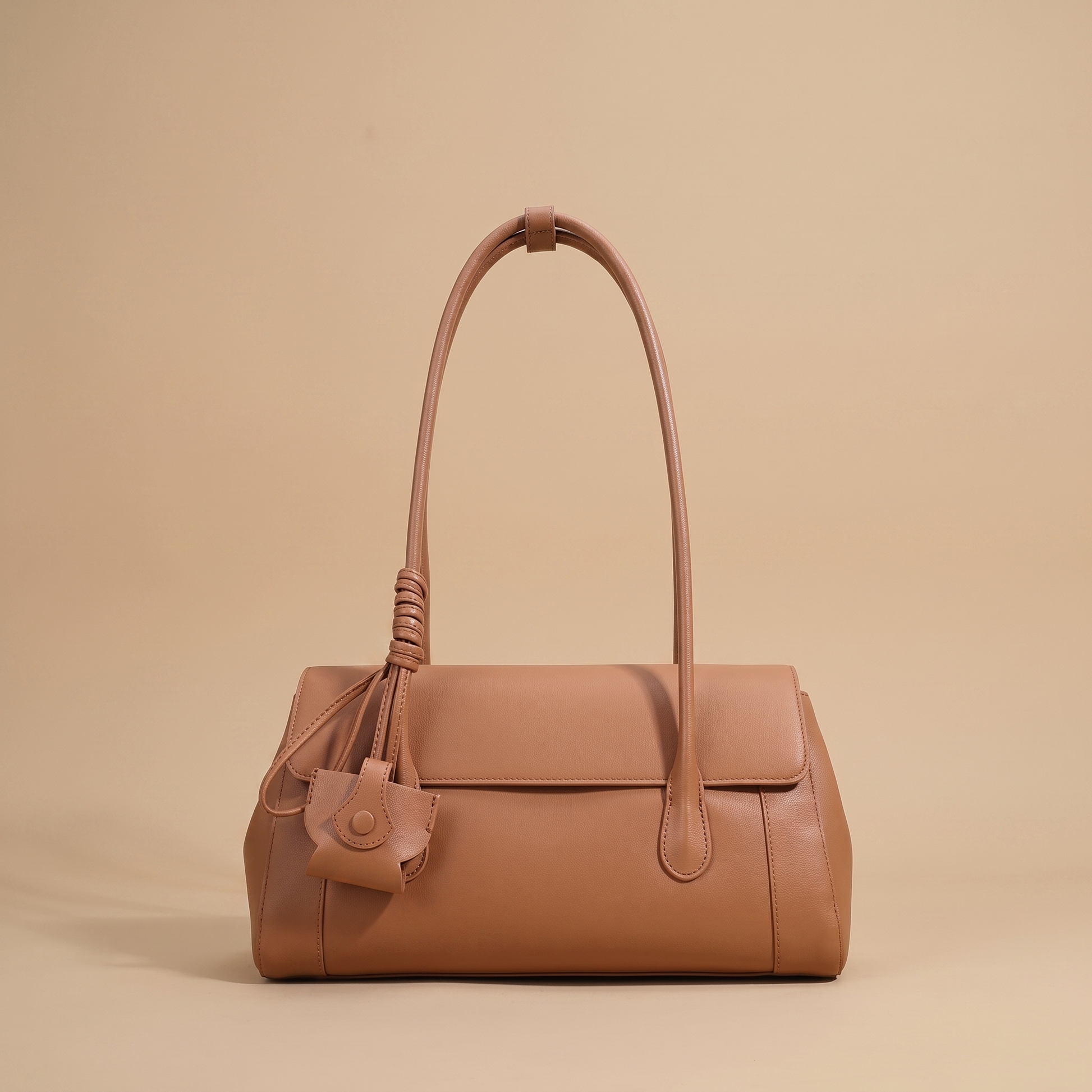 Colette Structured Leather Shoulder Bag in Cognac on a warm sand studio backdrop
