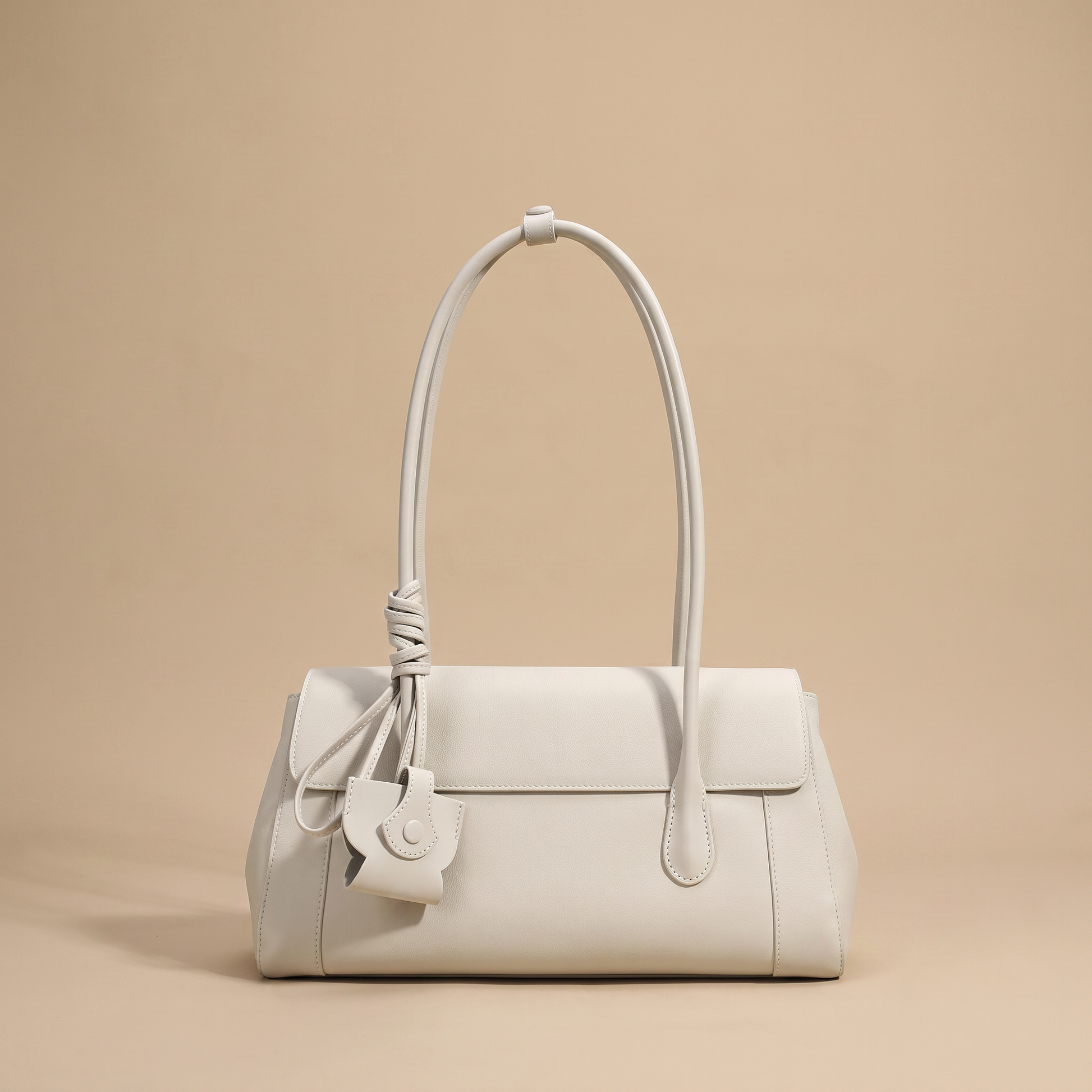 Colette Structured Leather Shoulder Bag in Ivory on a warm sand studio backdrop