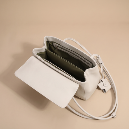 Colette bag opened to show the olive-lined interior with divider and zip pocket